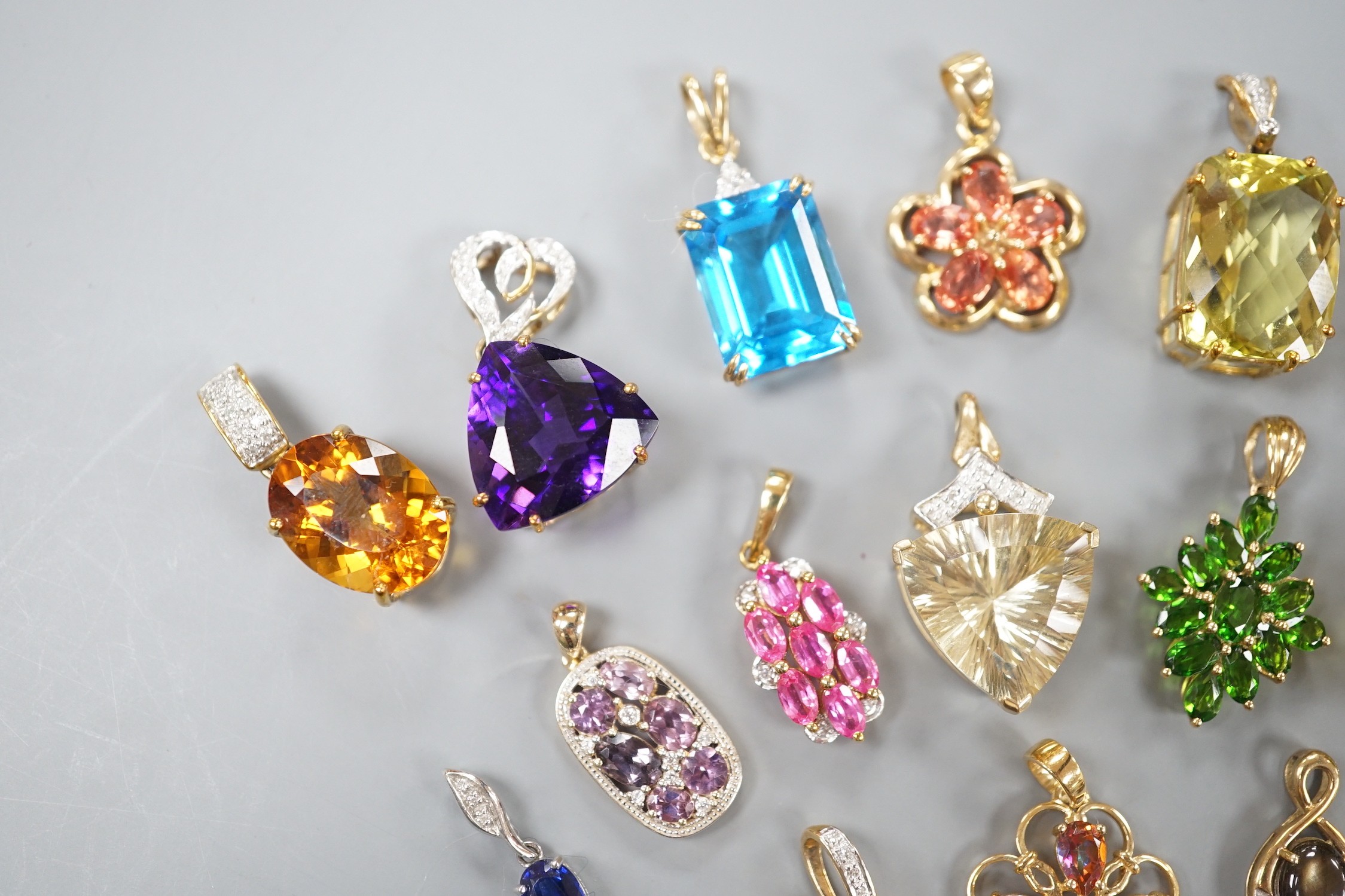 Nineteen assorted modern 9ct gold or yellow metal and gem set pendants, including citrine and amethyst and a 9ct gold chain, gross weight 63.6 grams.